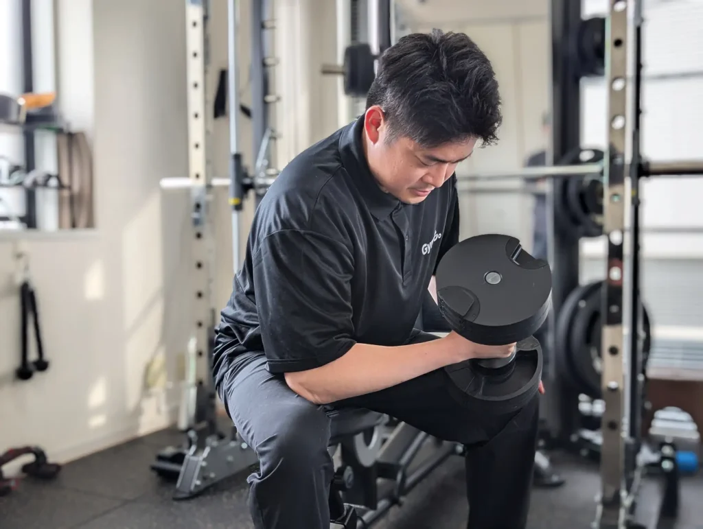 冨安トレーナーのアームカールトレーニングの写真