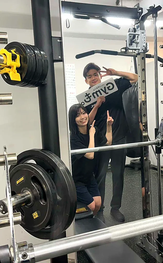 パーソナルジムGymも。のトレーニング設備前でボードを持つスタッフ